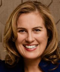 Melinda Smith. She is smiling wearing a dark blazer.