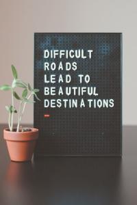 Image of pin board with words, “Difficult roads lead to beautiful destinations”.