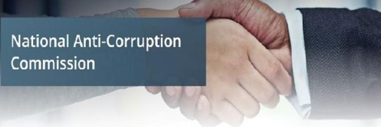 Image of two male hands shaking with a title overlaid saying, “National Anti-Corruption Commission”.