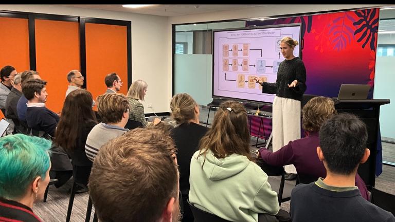 An image of Chloe Tallentire in a meeting room leading a discussion on Dragonfly Thinking