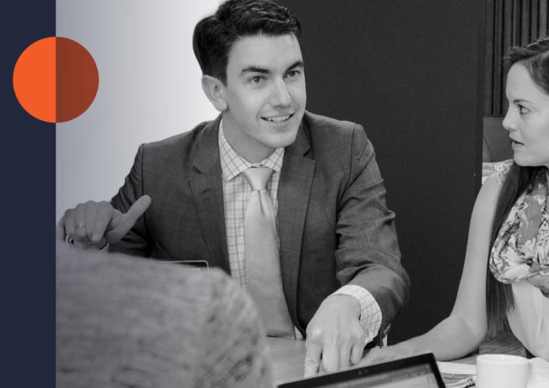 Stock image of two people have a discussion at a table.