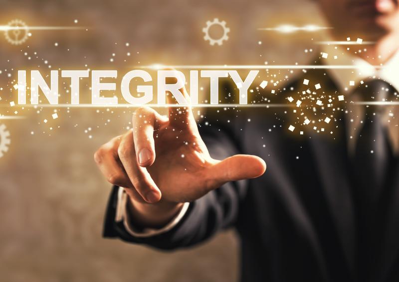 An illustrative image of a person pressing an ‘integrity’ word on a digital screen.