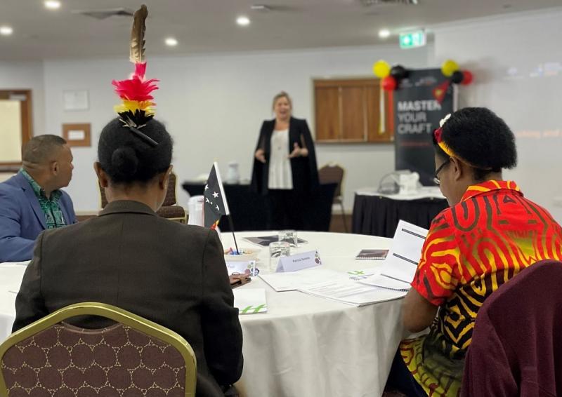 A photo of 3 participants sitting at a table for the pilot program in a room.