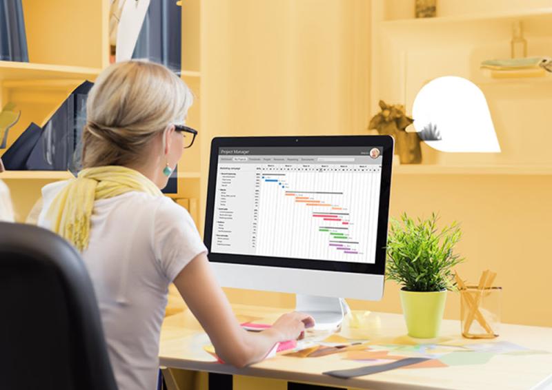 Person sitting at a desk with a graph on the screen