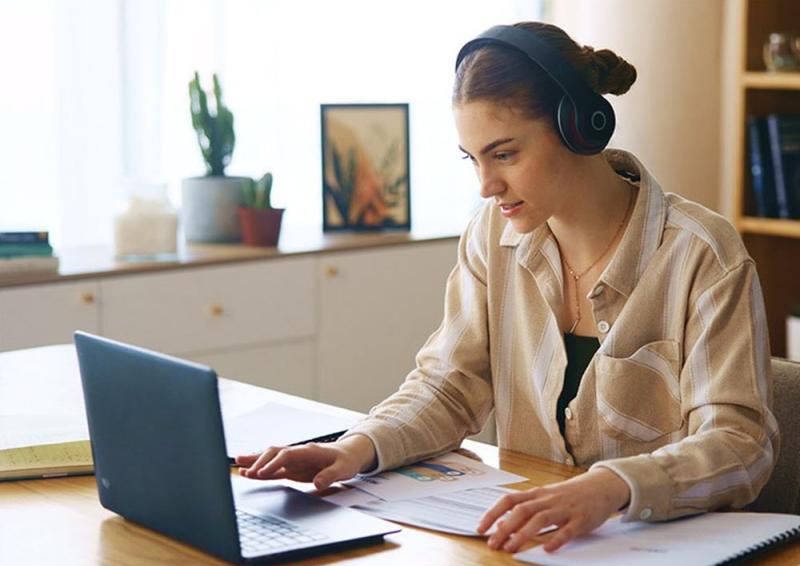 Person sitting at an office desk working on a laptop