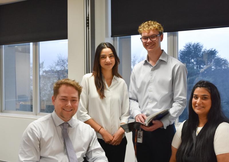 Team posing and smiling for photo in office setting