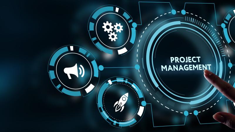 An image of  a screen with a person’s finger pressing a large button saying ‘Project Management’ 