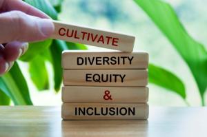 Illustrative image of stacked wooden building blocks with words written on them, “Cultivate, Diversity, Equity, & Inclusion”.