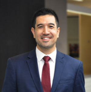 A head and shoulders photo of Joshua Saunders in a suit and tie.