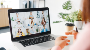 Women sitting at computer speaking with colleagues over online chat tool