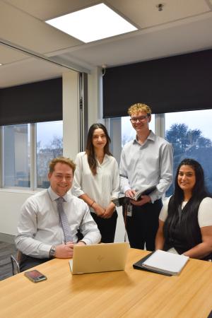 Team posing and smiling for photo in office setting