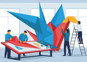 A collaborative team of people working together to construct a large, colourful, abstract origami sculpture.