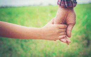 Adult hand holding a child's hand