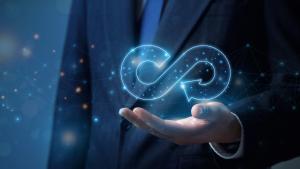 Businessman holding 'reuse', infinity symbol icon in his hand.