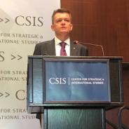 Andrew Colvin, Integrity Faculty, stands at a lectern delivering a speech. 