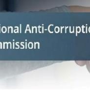 mage of two male hands shaking with a title overlaid saying, “National Anti-Corruption Commission”.