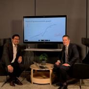 Dr Shiro Armstrong and Dr Paul Hubbard sitting in front of a screen with a graph displaying the Phases of Japanese growth.