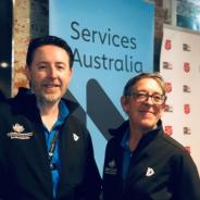 Photo in front of pull up banner of two people - CPSOs Nick and Rosemary - at the Community Partnership Pilot at Project 614, Salvation Army in Melbourne.