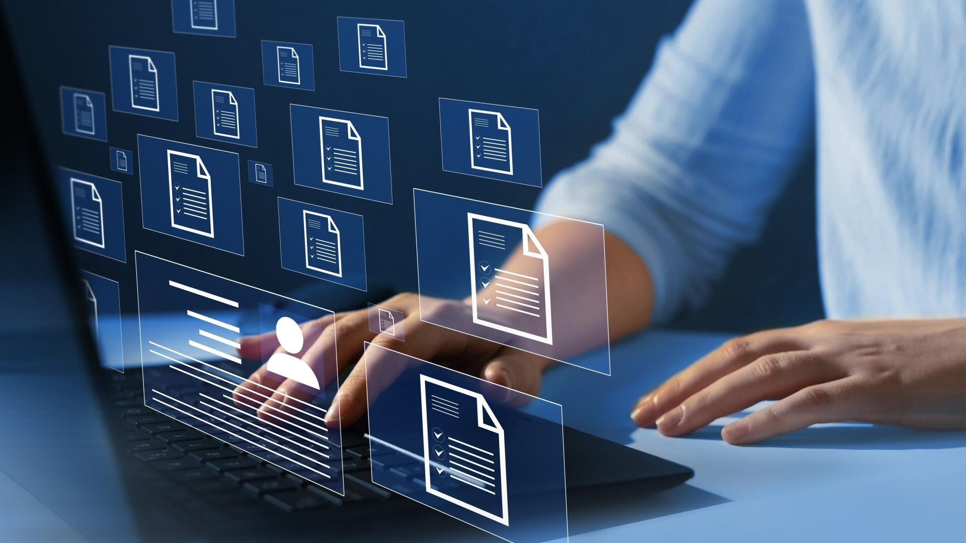 Illustrative image of person’s hands at laptop with overlay of document icons hovering in mid air in front of the person.