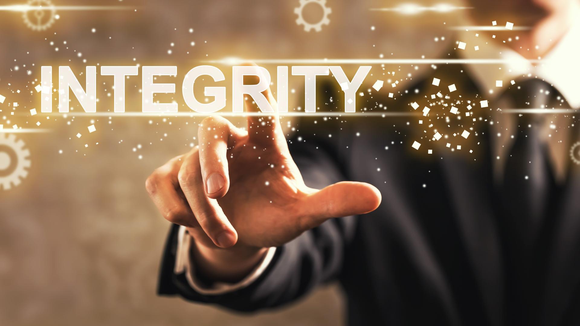 An illustrative image of a person pressing an ‘integrity’ word on a digital screen.