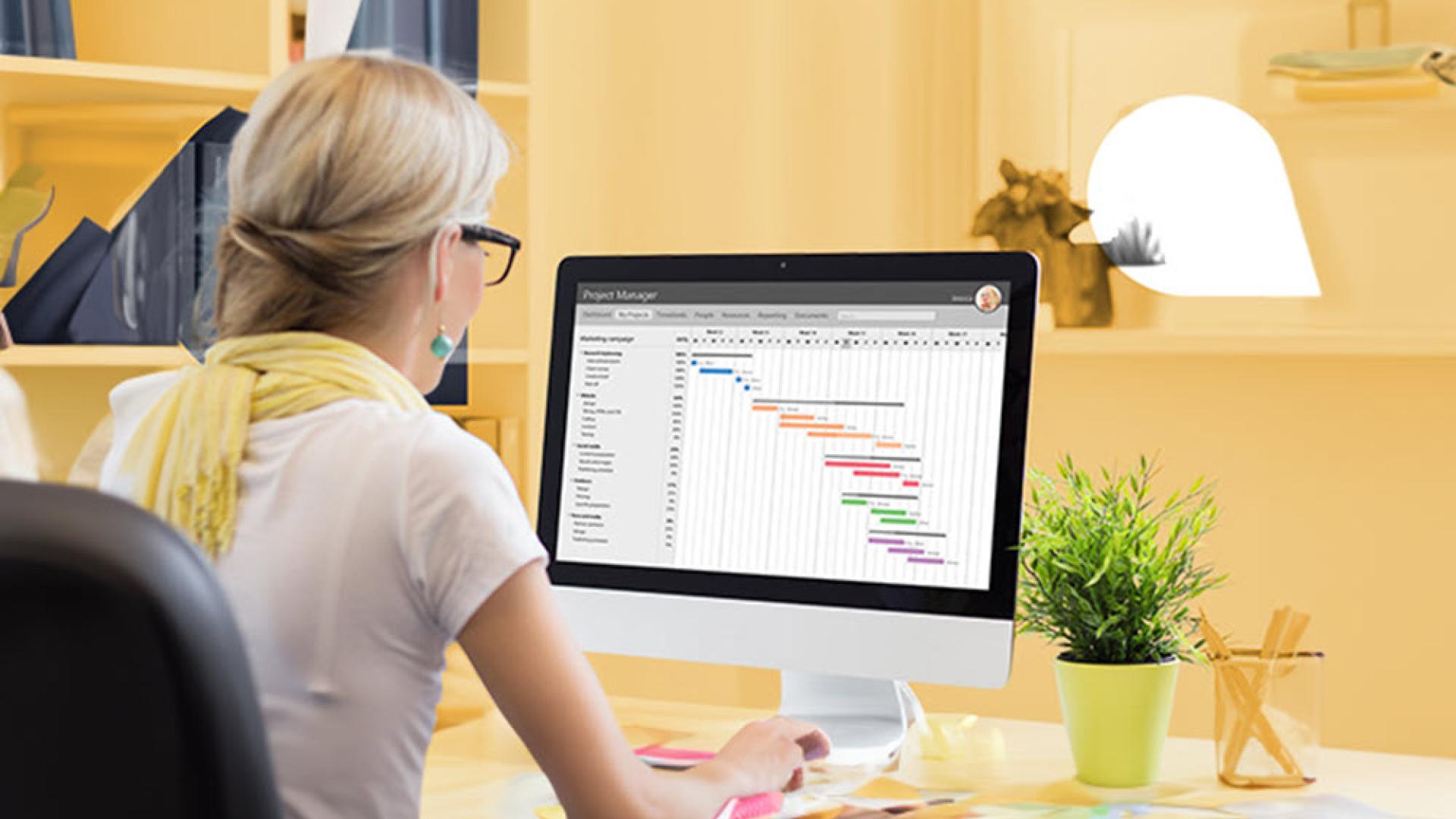 Person sitting at a desk with a graph on the screen