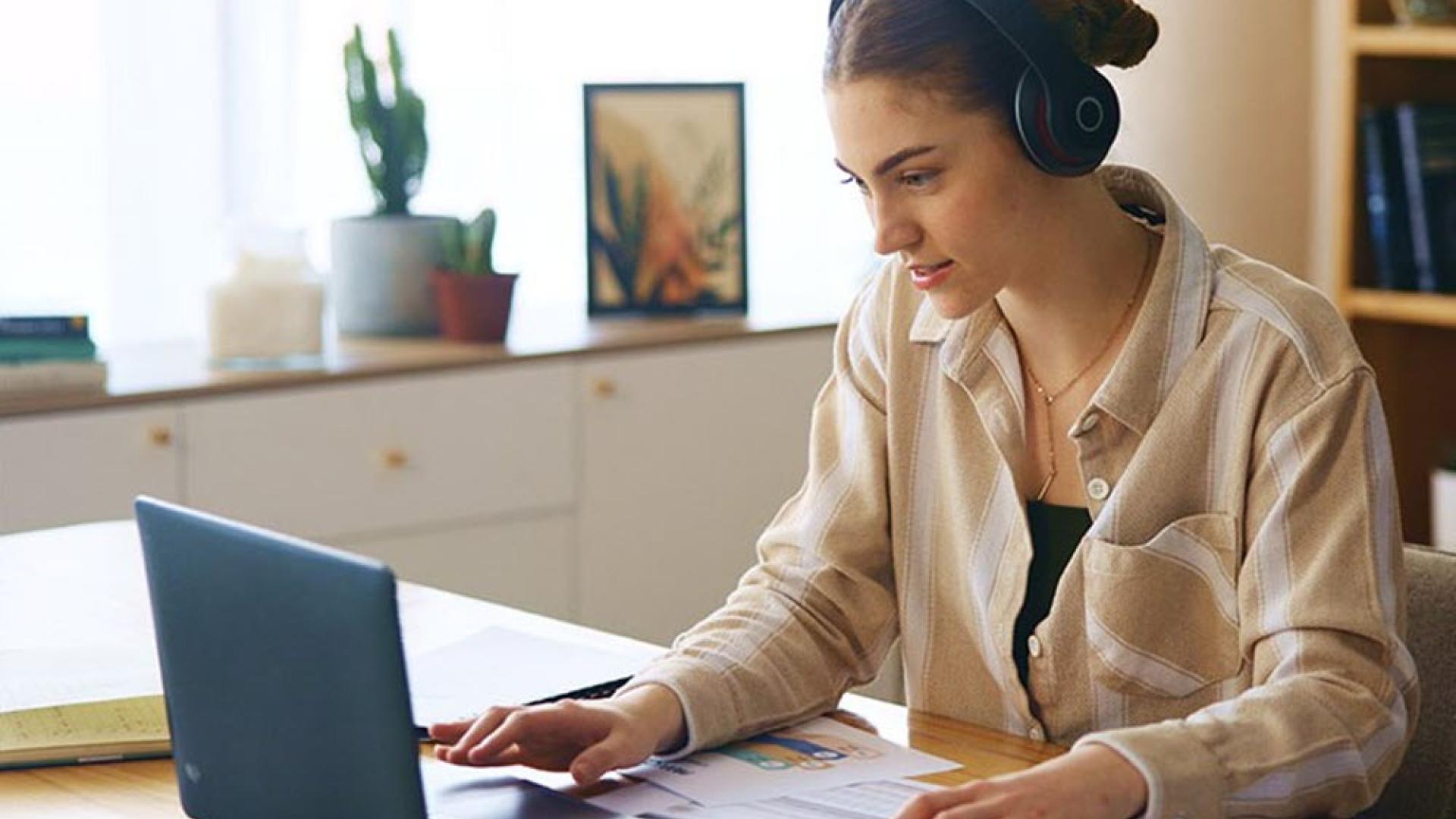 Person sitting at an office desk working on a laptop