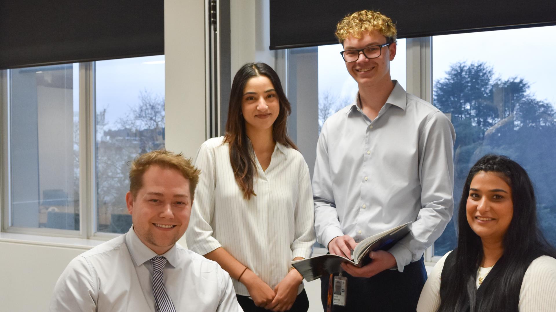 Team posing and smiling for photo in office setting