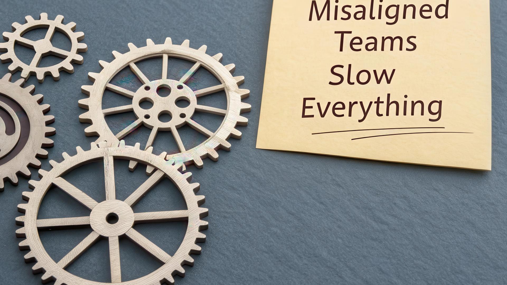 An illustration of 4 cogged wheels overlapping, not in alignment plus post it note with wording, ‘’misaligned teams slow everything’.