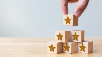 Hand arranging wood block stacking as step stair with five star shape.