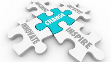 White puzzle pieces with words such as "INNOVATE," "IMAGINE," "IMPROVE," and "INSPIRE" surround a central blue puzzle piece labelled "CHANGE."