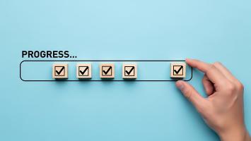 Hand placing a checked box into a progress bar
