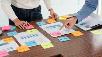 Creative group of business people brainstorming use sticky notes picking to share idea on table.