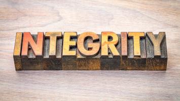 integrity - word abstract in letterpress wood type blocks against grained wood
